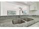 Stainless steel sink with granite countertop, plus view to the living space beyond at 13612 S Village Dr # 5201, Tampa, FL 33618