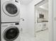 Laundry room with a stacked washer/dryer leading into a bright, updated kitchen with white cabinetry at 13612 S Village Dr # 5201, Tampa, FL 33618