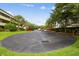 Paved parking area beside the condo building, bordered with mature trees and manicured greenery at 13612 S Village Dr # 5201, Tampa, FL 33618