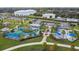Aerial view of a colorful playground with splash pad, climbing structures, and picnic area in a well-maintained community park at 13612 S Village Dr # 5201, Tampa, FL 33618