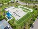 Aerial view of an outdoor skate park featuring ramps, rails, and a smooth concrete surface, surrounded by green space at 13612 S Village Dr # 5201, Tampa, FL 33618