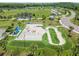 Aerial view showcasing the skate park's concrete ramps, a pump track, shaded picnic area, palm trees, and green spaces at 13612 S Village Dr # 5201, Tampa, FL 33618
