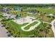 Aerial view of the skate park highlighting concrete ramps, a pump track, palm trees, green spaces, and proximity to the lake at 13612 S Village Dr # 5201, Tampa, FL 33618