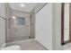 Bright bathroom featuring a sleek glass-enclosed shower with tiled walls, and linen closet at 1501 Doyle Carlton Dr # 303, Tampa, FL 33602