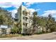 The exterior showcases modern architecture, multiple balconies, and lush landscaping surrounded by mature trees at 1501 Doyle Carlton Dr # 303, Tampa, FL 33602