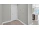 Hallway with a closet and a partial view of the open kitchen and balcony through sheer curtains at 1501 Doyle Carlton Dr # 303, Tampa, FL 33602