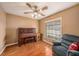 Comfortable bedroom with a ceiling fan, hardwood floors, and a cozy recliner near the window at 15820 Sapwood St, Tampa, FL 33624