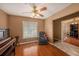 Comfortable bedroom with a ceiling fan, hardwood floors, and a cozy recliner near the window at 15820 Sapwood St, Tampa, FL 33624