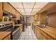 Well-lit kitchen with butcher block countertops, stainless steel appliances, and white tile flooring at 15820 Sapwood St, Tampa, FL 33624