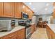 Well-equipped kitchen featuring wood cabinets, stainless steel appliances, and a cozy dining area at 15917 Crying Wind Dr, Tampa, FL 33624