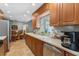Charming kitchen with wood cabinets, a stainless steel dishwasher, and a view to the outdoors at 15917 Crying Wind Dr, Tampa, FL 33624
