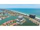 An aerial view of a waterfront condo community featuring boat docks, tennis courts, and stunning ocean views at 1651 Sand Key Estates Ct # 54, Clearwater Beach, FL 33767