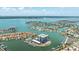 An aerial view of a beachfront community featuring waterfront condos, boat docks, and tennis courts at 1651 Sand Key Estates Ct # 54, Clearwater Beach, FL 33767