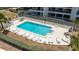 Aerial view of community pool with lounge chairs and landscaping at 1651 Sand Key Estates Ct # 54, Clearwater Beach, FL 33767
