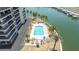 Aerial view of waterfront condo complex's rectangular community pool with lounge chairs and landscaping at 1651 Sand Key Estates Ct # 54, Clearwater Beach, FL 33767