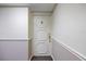 Elegant white entry door with classic gold hardware and decorative panels in a neutral hallway setting at 1651 Sand Key Estates Ct # 54, Clearwater Beach, FL 33767