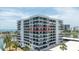 Modern condo building showcasing sleek design and waterfront views, accentuated by palm trees and sunny skies at 1651 Sand Key Estates Ct # 54, Clearwater Beach, FL 33767