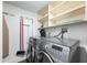 Functional laundry room features modern appliances, storage shelving, and wall-mounted ironing board at 1651 Sand Key Estates Ct # 54, Clearwater Beach, FL 33767