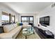 Modern living room showcasing a comfortable sectional, stylish decor, and views of the outside cityscape through large windows at 1651 Sand Key Estates Ct # 54, Clearwater Beach, FL 33767