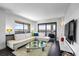 Comfortable living room features a large sectional, sleek furniture, and a balcony with scenic water and city views at 1651 Sand Key Estates Ct # 54, Clearwater Beach, FL 33767