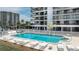 A beautiful, sparkling pool is surrounded by lounge chairs at this beachfront condo community at 1651 Sand Key Estates Ct # 54, Clearwater Beach, FL 33767