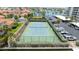 An aerial shot of a community tennis court, surrounded by lush landscaping and waterfront views at 1651 Sand Key Estates Ct # 54, Clearwater Beach, FL 33767