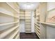 Spacious walk-in closet features custom built-in shelving and ample storage space for organization at 1651 Sand Key Estates Ct # 54, Clearwater Beach, FL 33767