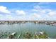 Expansive water view featuring a tranquil bay, boat docks, and waterfront homes under a sunny, cloud-dotted sky at 1651 Sand Key Estates Ct # 54, Clearwater Beach, FL 33767