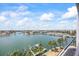 Beautiful water view overlooking boat docks, palm trees, and a scenic waterfront community on a sunny, cloud-filled day at 1651 Sand Key Estates Ct # 54, Clearwater Beach, FL 33767