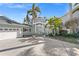 Beautiful two story home featuring a grand entrance, lush landscaping, and a spacious three car garage at 17077 Dolphin Dr, North Redington Beach, FL 33708