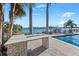Backyard kitchen with a brick bar, sink, stainless grill, outdoor seating, and a pool along the water at 17077 Dolphin Dr, North Redington Beach, FL 33708