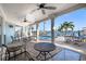 Inviting covered patio with outdoor seating, ceiling fans, and gorgeous waterfront views at 17077 Dolphin Dr, North Redington Beach, FL 33708