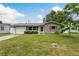 Charming single-story home featuring a well-maintained lawn and a tidy front garden at 2020 Douglas Ave, Dunedin, FL 34698