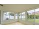 Enclosed sunroom featuring ample windows for natural light and access to the backyard at 2020 Douglas Ave, Dunedin, FL 34698