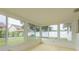 Bright sunroom with large windows offering views of the backyard and lush landscape at 2020 Douglas Ave, Dunedin, FL 34698
