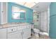 Bright bathroom features a modern vanity, decorative mirror, and tiled walk-in shower with glass door at 2096 Massachusetts Ne Ave, St Petersburg, FL 33703