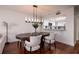 Open dining room with a modern chandelier and view into the kitchen featuring a breakfast bar at 222 Skiff Pt, Clearwater, FL 33767