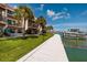 Waterfront living with dock, lush green lawn, mature palm trees, and condo building at 222 Skiff Pt, Clearwater, FL 33767