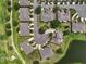 An aerial view showcases homes nestled in a golf course community with lush greenery and a serene pond at 2490 Kensington Greens Dr # 0, Sun City Center, FL 33573