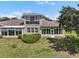 Well-maintained backyard showing a sunroom, lush lawn, manicured bushes and mature landscaping at 2490 Kensington Greens Dr # 0, Sun City Center, FL 33573