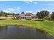 Expansive backyard with a serene pond view, lush green lawn, and spacious screened-in porch at 2490 Kensington Greens Dr # 0, Sun City Center, FL 33573