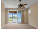 Spacious bedroom featuring a ceiling fan and sliding glass doors leading to a screened patio at 2490 Kensington Greens Dr # 0, Sun City Center, FL 33573