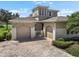Stunning home exterior featuring a three-car garage, brick-paved driveway, and well-manicured landscaping at 2490 Kensington Greens Dr # 0, Sun City Center, FL 33573