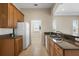 Kitchen featuring tile floors, wood cabinets, granite counters, and white appliances at 2490 Kensington Greens Dr # 0, Sun City Center, FL 33573