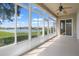 Enclosed lanai featuring scenic lake views, ceiling fan, and ample natural light at 2490 Kensington Greens Dr # 0, Sun City Center, FL 33573