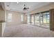 Spacious living room with neutral carpet, ceiling fan, and sliding glass doors at 2490 Kensington Greens Dr # 0, Sun City Center, FL 33573