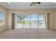 Living room with neutral walls and sliding glass doors overlooking the lake at 2490 Kensington Greens Dr # 0, Sun City Center, FL 33573