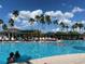 Outdoor swimming pool surrounded by palm trees and lounge chairs, perfect for relaxation and recreation on a sunny day at 2490 Kensington Greens Dr # 0, Sun City Center, FL 33573
