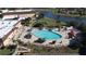 Aerial view of a large pool surrounded by sun umbrellas, chairs, and palm trees at 2490 Kensington Greens Dr # 0, Sun City Center, FL 33573