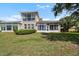 A sunroom with bright, natural light looks out over the manicured lawn at 2490 Kensington Greens Dr # 0, Sun City Center, FL 33573